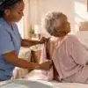 Caregiver open back top Caregiver helping senior woman with an open-back top