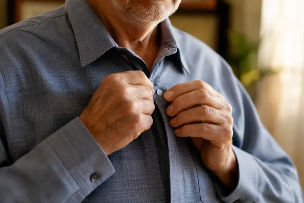 Close-up of hands fastening a magnetic closure shirt, older man