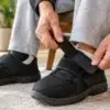 Close-up of hands fastening velcro adaptive shoes